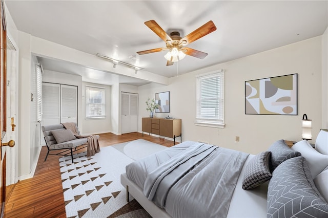 bedroom featuring multiple windows, ceiling fan, and hardwood / wood-style flooring