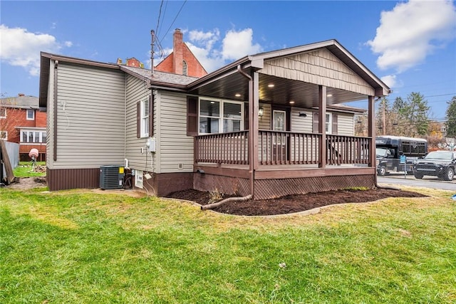 back of property with a lawn, central AC, and a porch