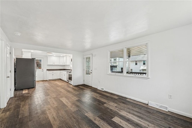 unfurnished living room with dark hardwood / wood-style flooring