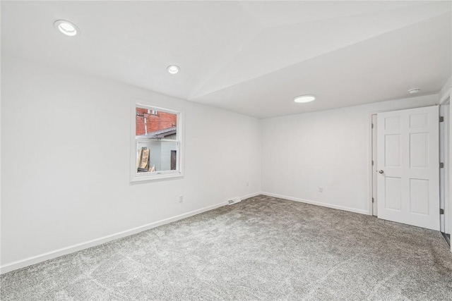 empty room with carpet and vaulted ceiling