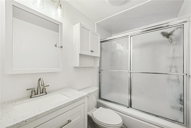 full bathroom featuring vanity, toilet, and shower / bath combination with glass door