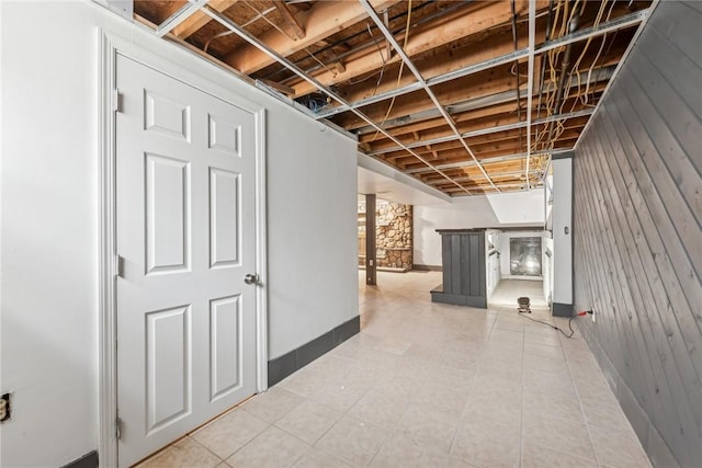 basement featuring wooden walls