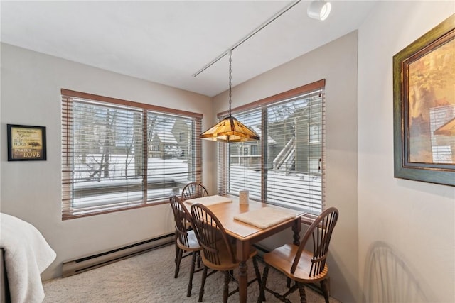 carpeted dining area with plenty of natural light and baseboard heating