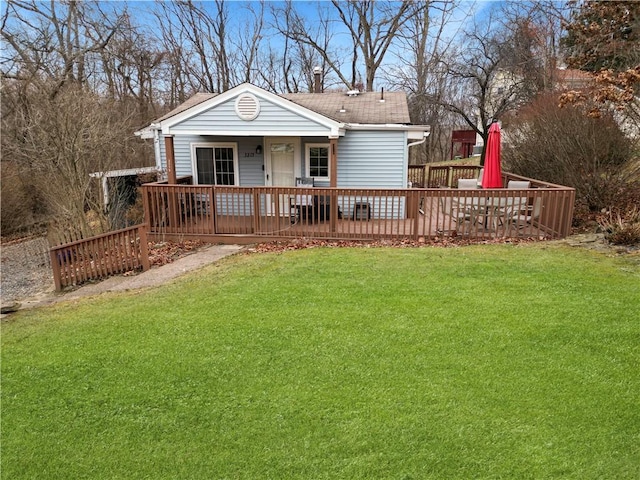 rear view of house with a yard and a wooden deck