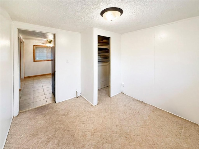 unfurnished bedroom with a textured ceiling, light carpet, and a closet