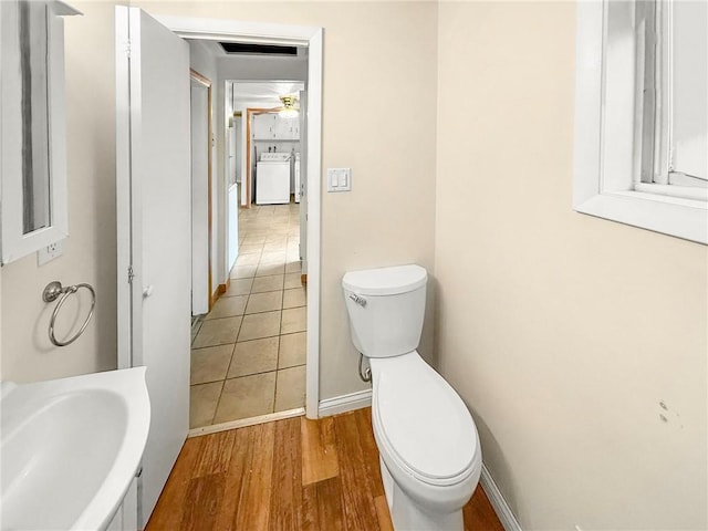 bathroom featuring washer / clothes dryer, sink, wood-type flooring, and toilet