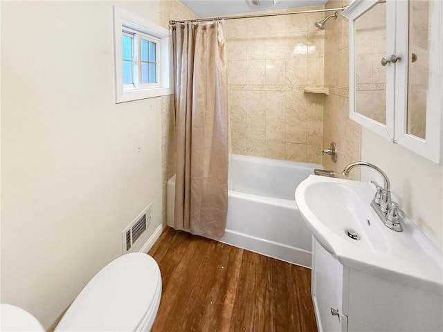 full bathroom featuring shower / tub combo, vanity, hardwood / wood-style flooring, and toilet