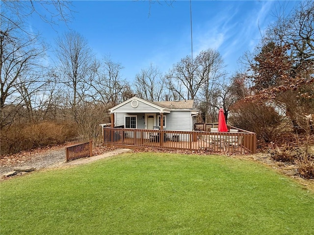 back of property featuring a deck and a lawn