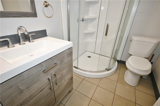 bathroom with tile patterned floors, toilet, vanity, and walk in shower