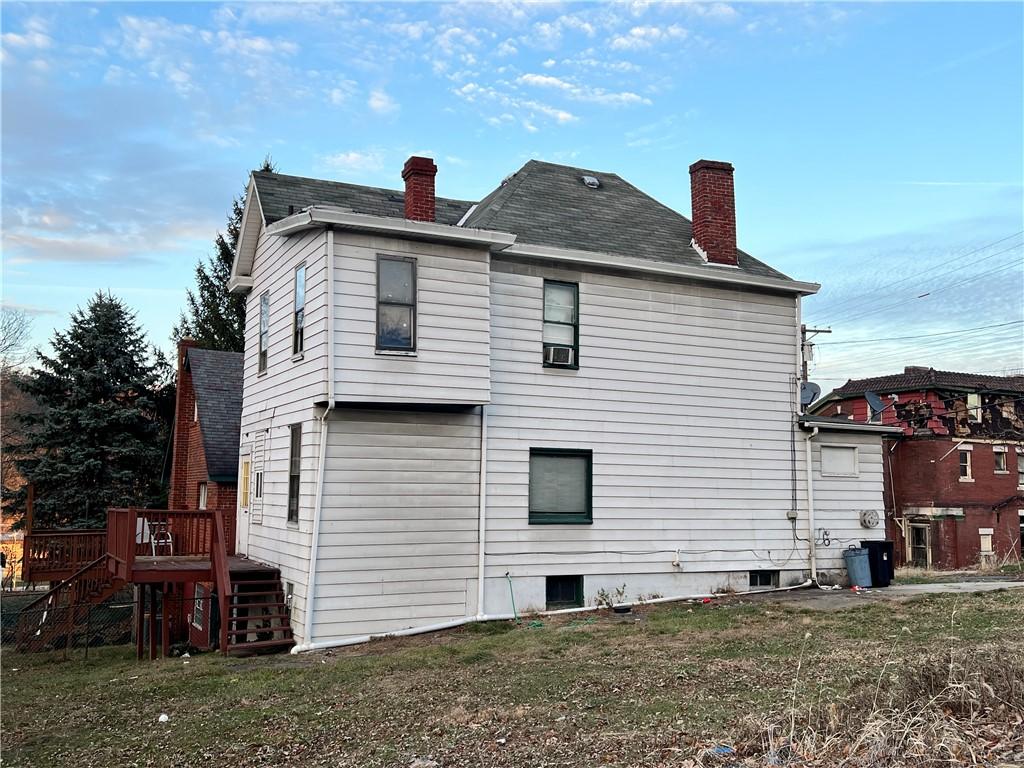 back of house with a yard and a deck