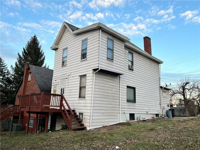 rear view of property with a wooden deck and a yard