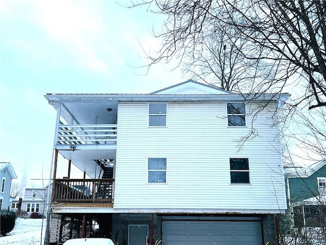 rear view of house with a balcony and a garage