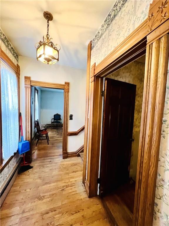 hallway with hardwood / wood-style floors and a baseboard radiator