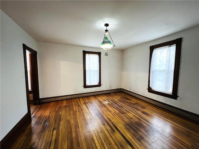 empty room featuring dark wood-style floors, baseboards, and a baseboard heating unit