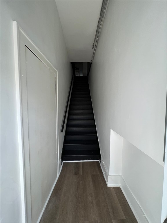 staircase with baseboards and wood finished floors