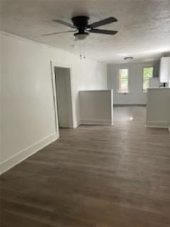 unfurnished room with baseboards, a ceiling fan, and wood finished floors