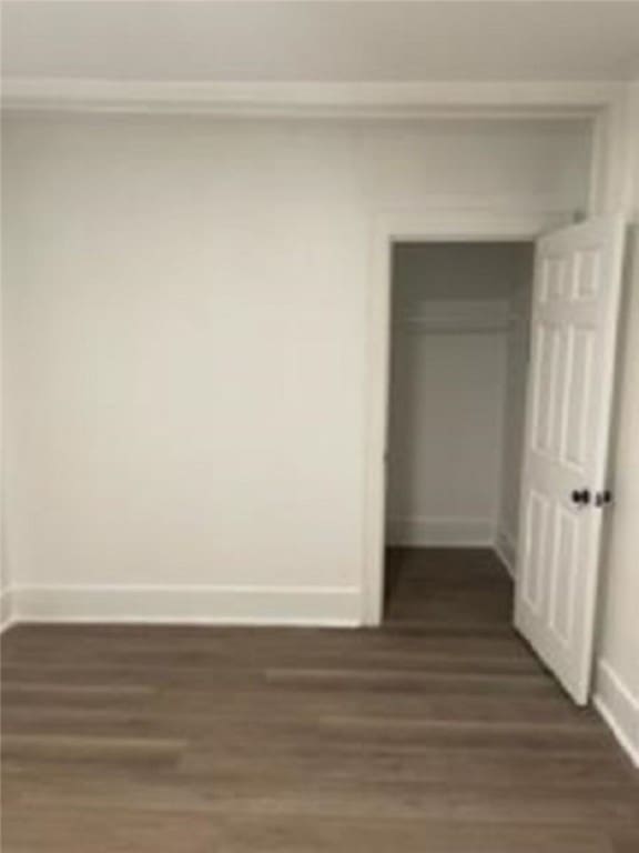 interior space with a closet, baseboards, and dark wood-style floors
