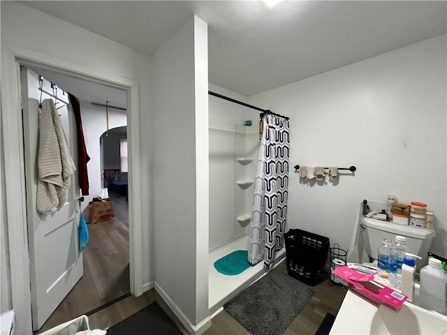 bathroom with toilet, shower / tub combo, and hardwood / wood-style flooring