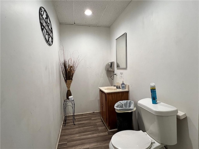 bathroom featuring vanity, wood finished floors, toilet, and a paneled ceiling
