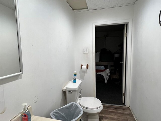 bathroom featuring toilet, a paneled ceiling, and wood finished floors