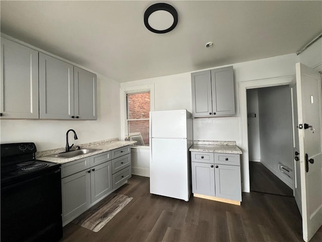 kitchen with gray cabinetry, black range with electric stovetop, freestanding refrigerator, and a sink