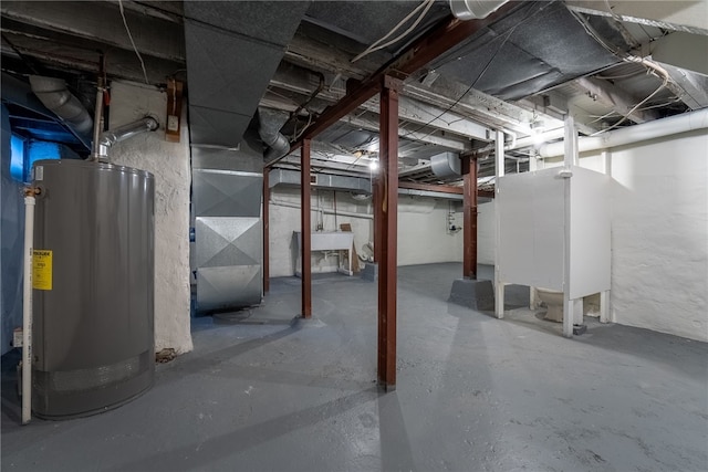 basement featuring gas water heater, sink, and heating unit