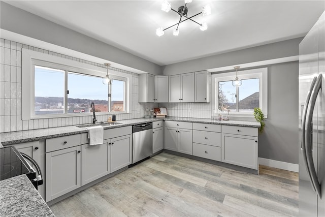 kitchen featuring appliances with stainless steel finishes, light hardwood / wood-style floors, and plenty of natural light