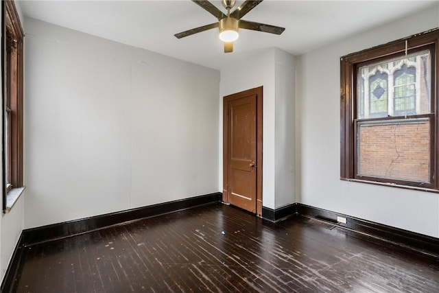 unfurnished room with ceiling fan and dark wood-type flooring