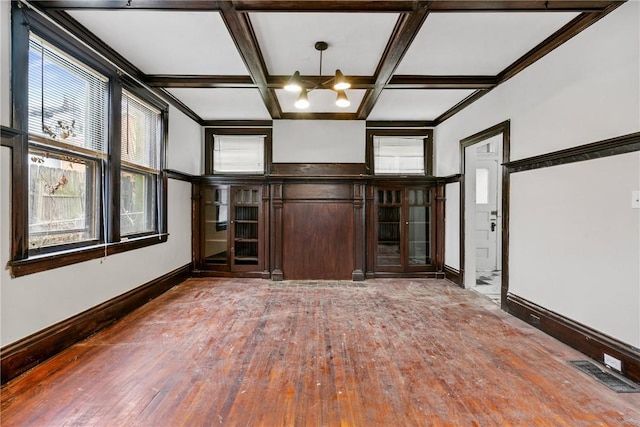 spare room with a chandelier, beam ceiling, hardwood / wood-style flooring, and coffered ceiling