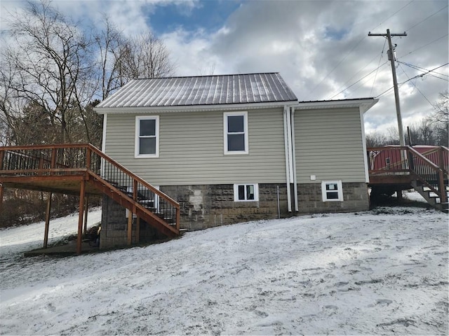 snow covered house featuring a wooden deck