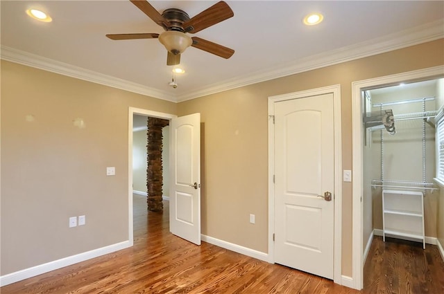 unfurnished bedroom featuring ceiling fan, hardwood / wood-style floors, and ornamental molding