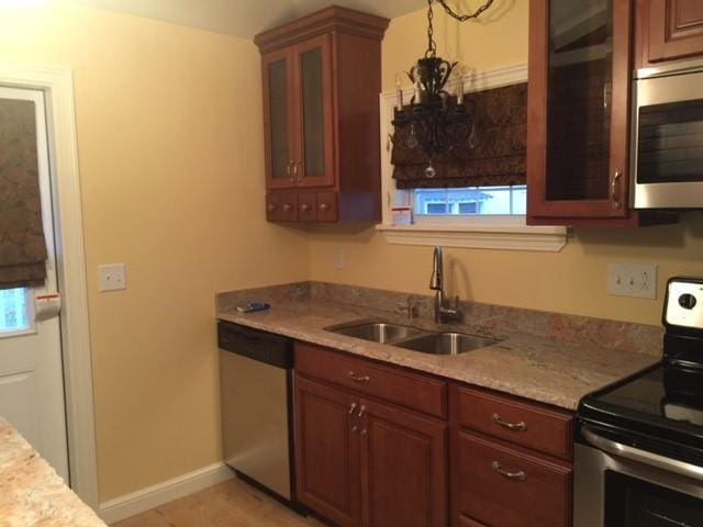 kitchen featuring light stone counters, sink, and stainless steel appliances