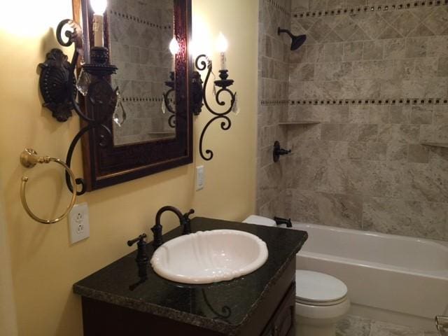 full bathroom featuring vanity, toilet, and tiled shower / bath combo