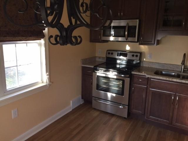 kitchen with dark hardwood / wood-style flooring, sink, dark brown cabinets, and stainless steel appliances