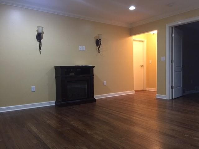 interior space with dark hardwood / wood-style flooring and ornamental molding