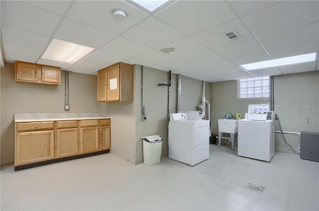 clothes washing area with cabinets, independent washer and dryer, and sink