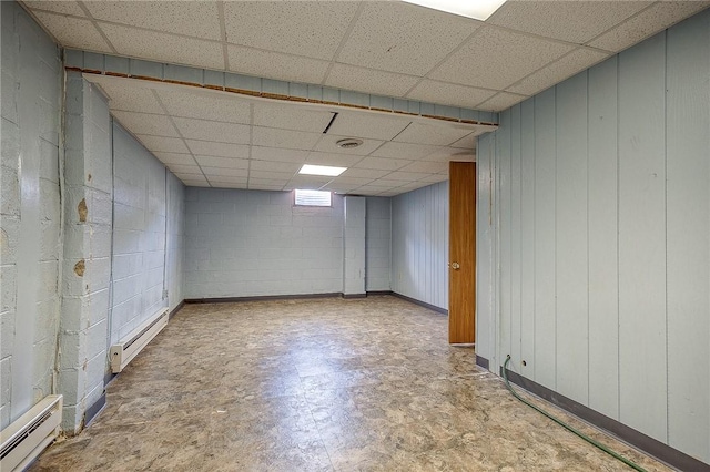 basement featuring a baseboard radiator and a drop ceiling