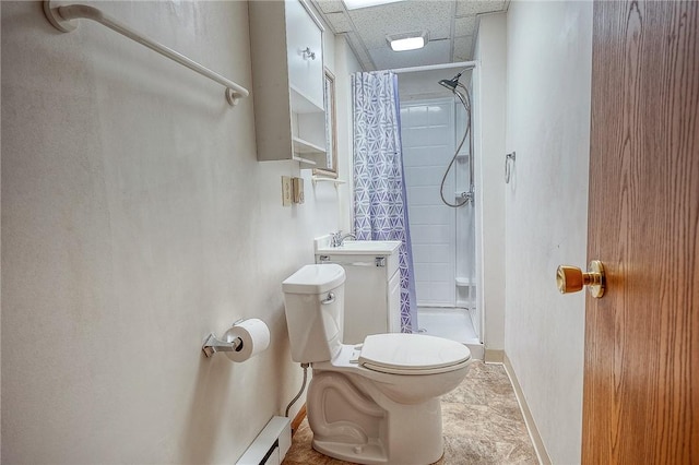 bathroom featuring a paneled ceiling, a shower with curtain, toilet, and sink