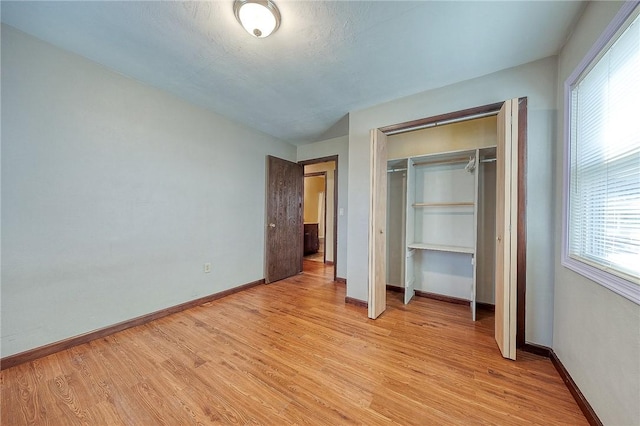 unfurnished bedroom featuring light hardwood / wood-style floors and a closet