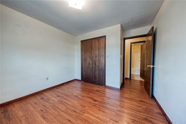 unfurnished bedroom with a closet and hardwood / wood-style floors