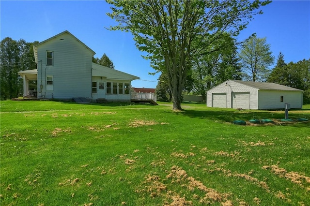 view of yard with a garage, an outdoor structure, and a wooden deck