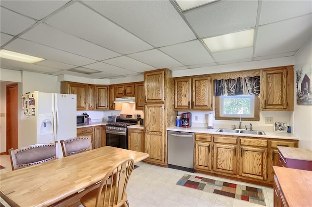 kitchen with a drop ceiling, sink, and appliances with stainless steel finishes