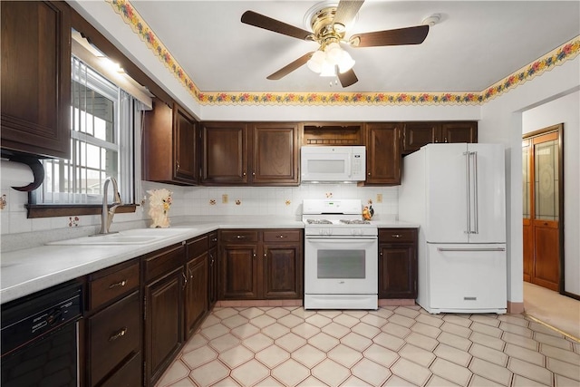 kitchen featuring dark brown cabinetry, ceiling fan, sink, and white appliances