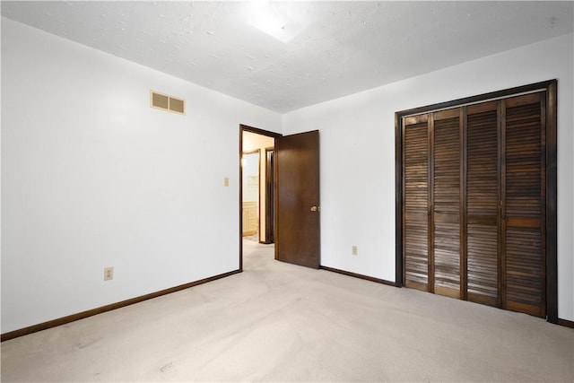 unfurnished bedroom with light carpet and a closet