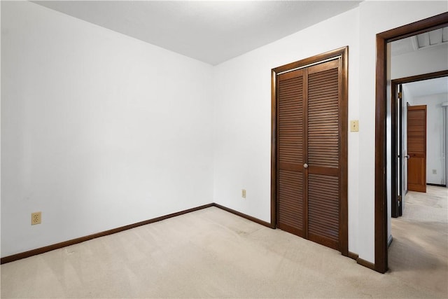 unfurnished bedroom with light colored carpet and a closet