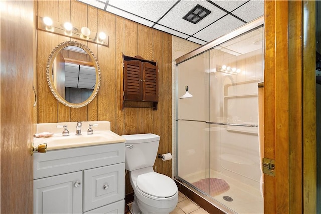 bathroom with a paneled ceiling, vanity, a shower with door, and wooden walls