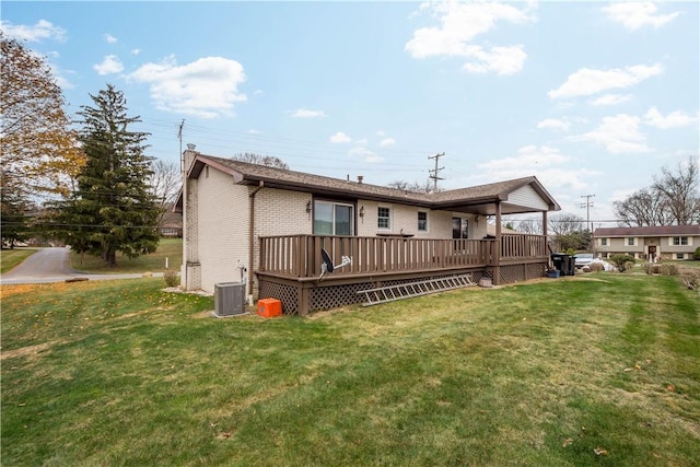 back of property with a lawn, central AC, and a deck