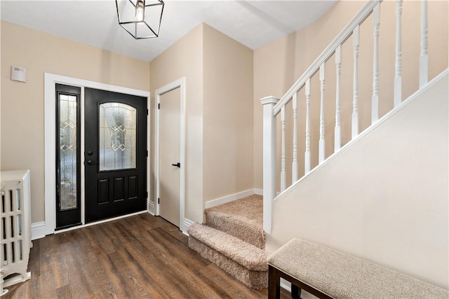 foyer entrance with radiator and dark hardwood / wood-style floors