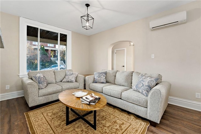 living room featuring a wall unit AC and dark hardwood / wood-style floors