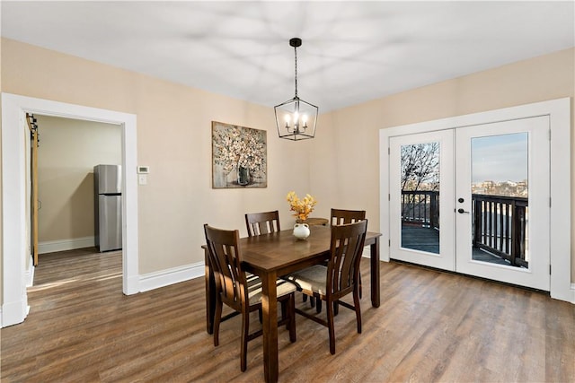 dining area featuring a notable chandelier, dark hardwood / wood-style flooring, and french doors